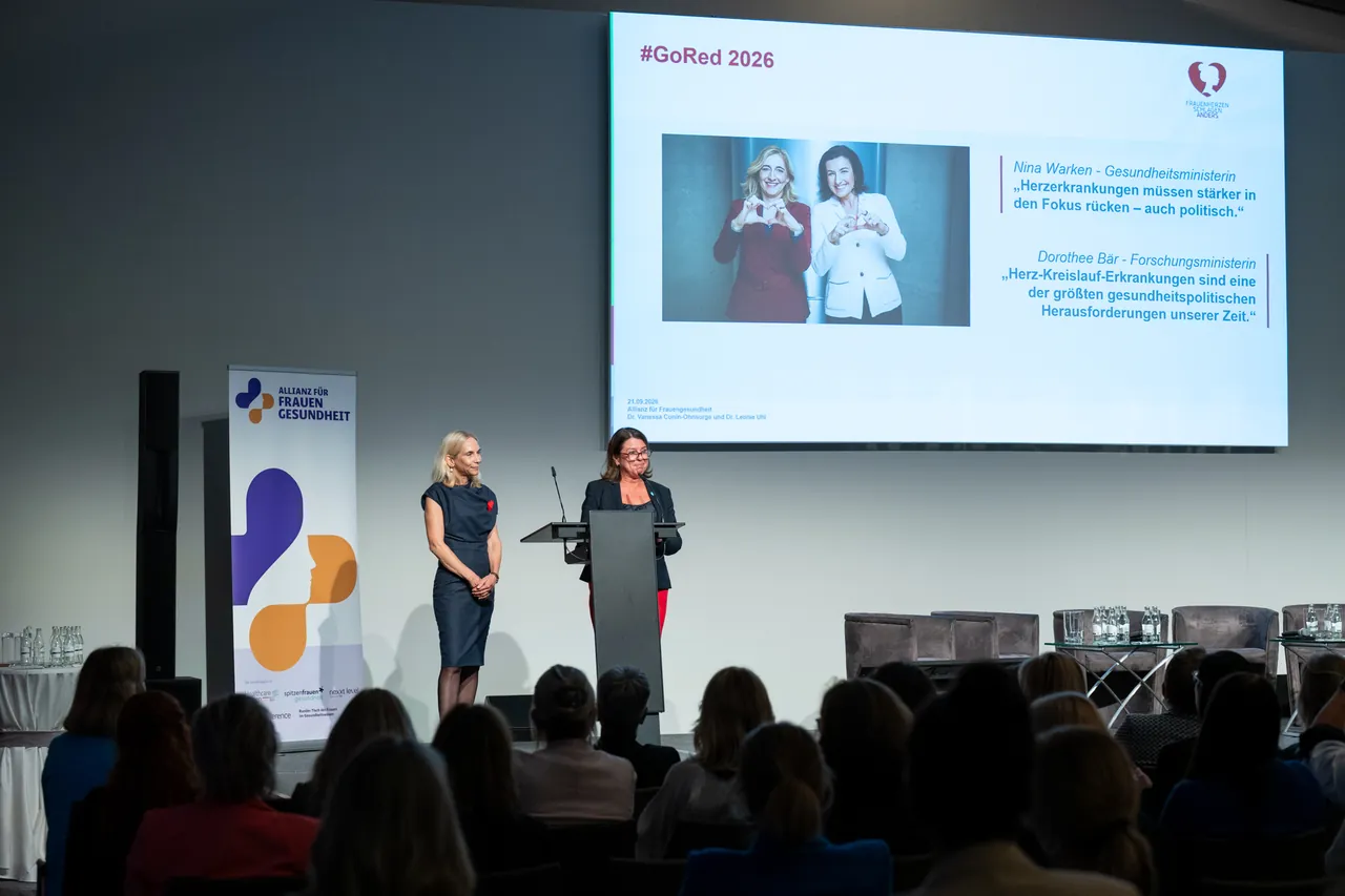 Zwei Frauen auf der Bühne vor einer Präsentation zu #GoRed 2026